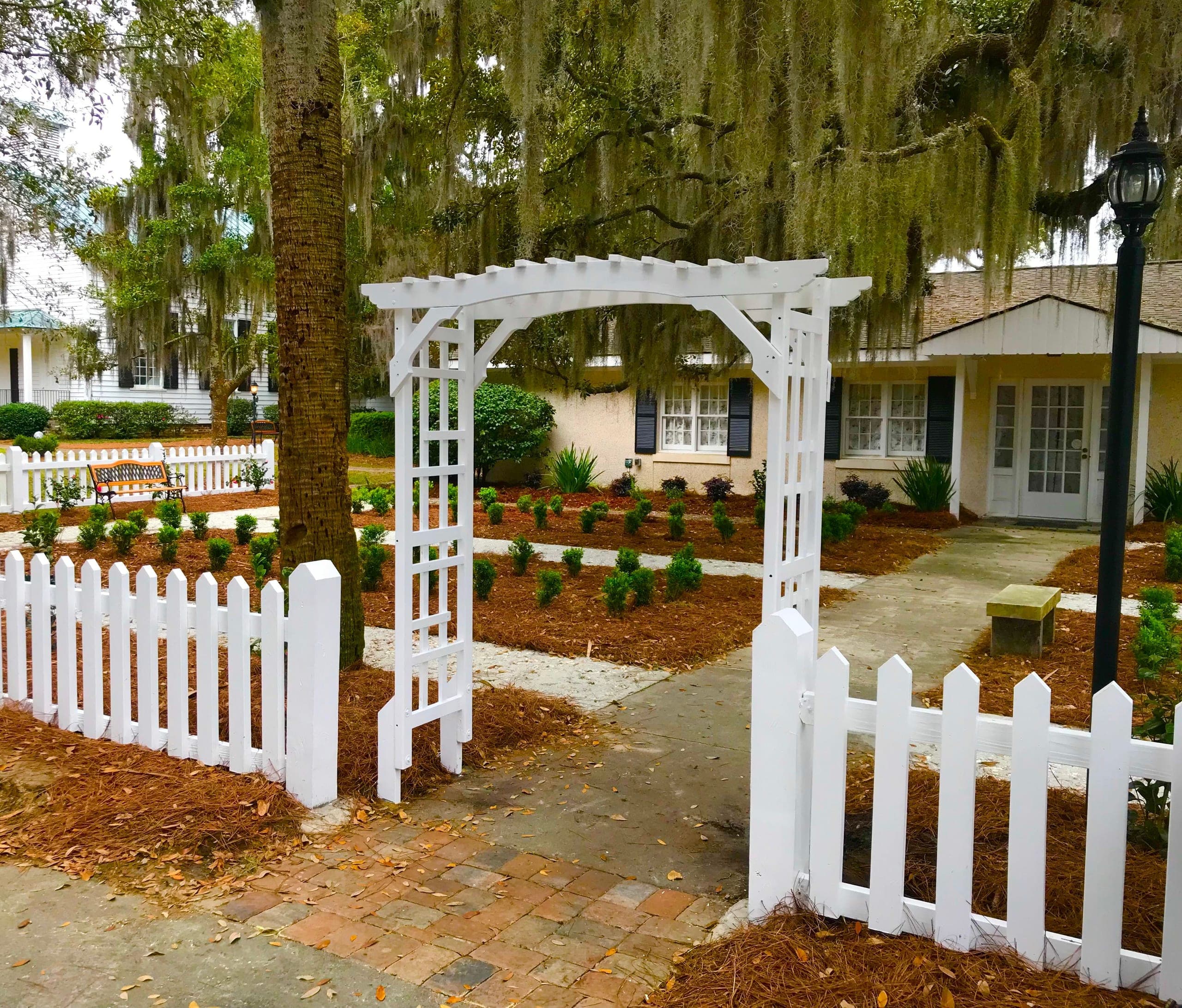 Boxwood parterres and a white arbor in the memory garden at Isle of Hope.